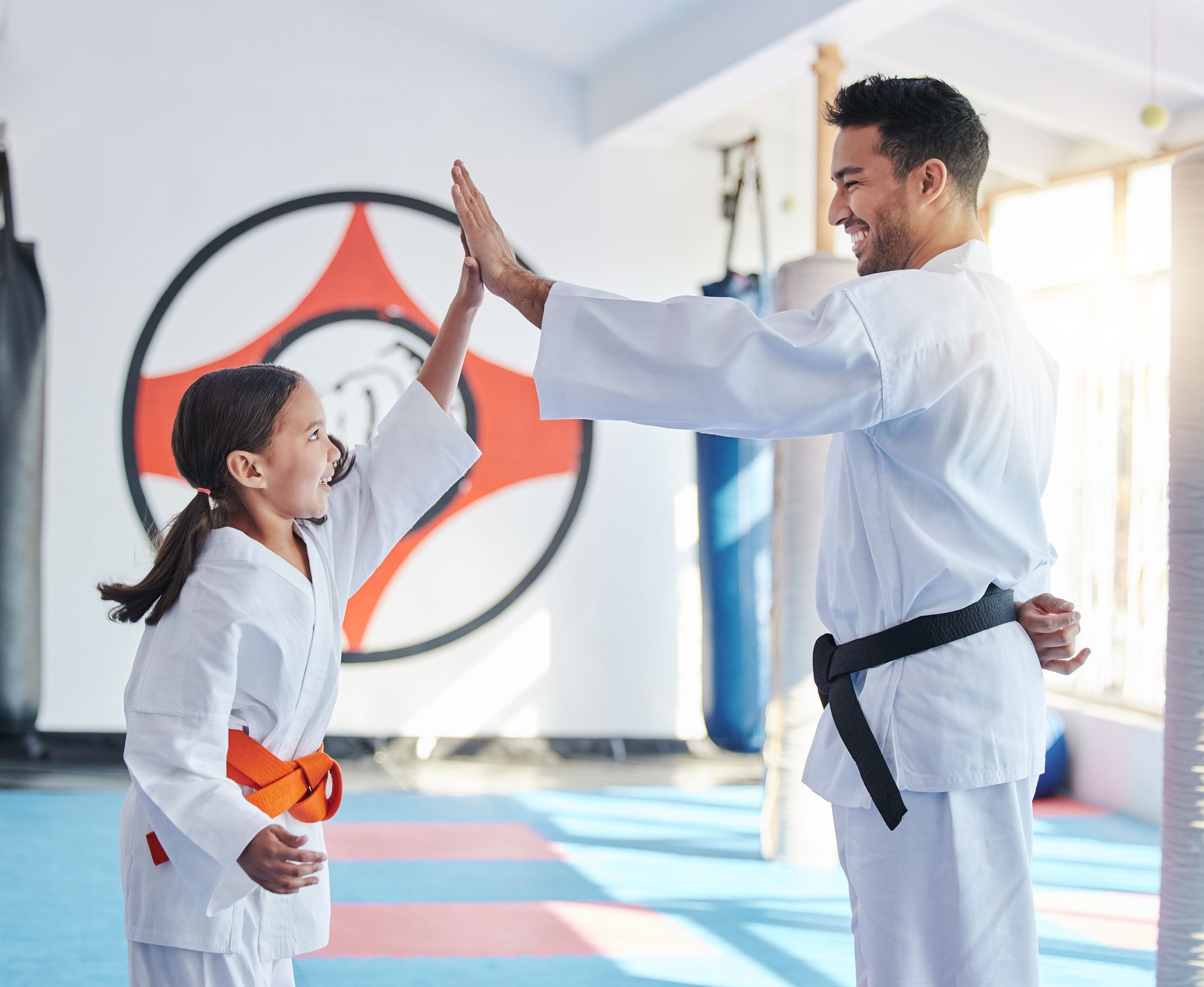 Shot of a young man and cute little girl practicing karate in a studio